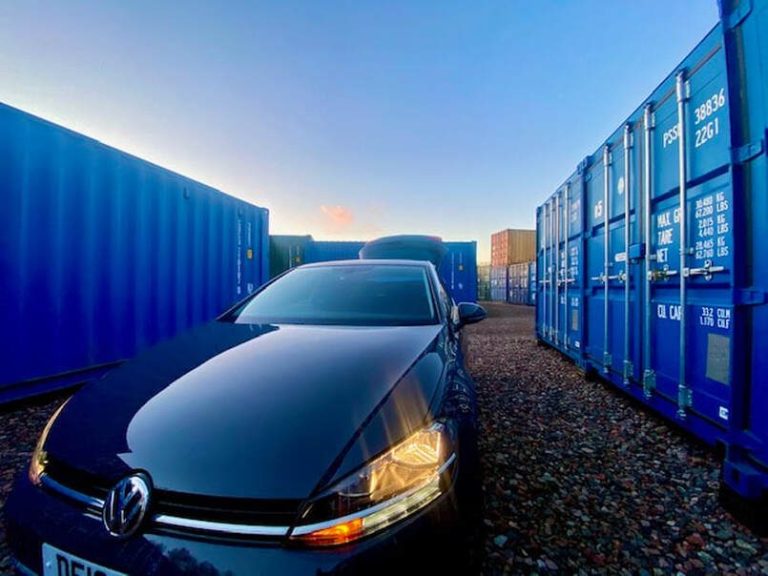 A promotional poster for self-storage units in Carlisle, featuring a car and storage containers.